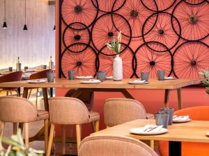 a restaurant with tables and chairs and a wall with umbrellas at Mercure Porto Centro Santa Catarina in Porto