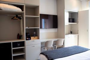 a bedroom with a bed and a kitchen with white cabinets at My Residence d'Azur in Beausoleil