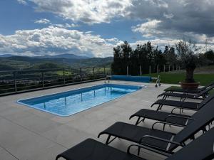 a swimming pool with chairs and a view of the mountains at Za Łyską - Żywiecka Perła in Żywiec