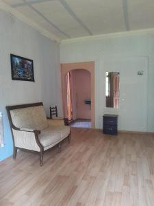 a living room with a couch and a wooden floor at Motena Guesthouse in Martvili