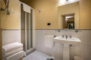 a bathroom with a sink and a mirror and towels at Palazzo Gamba Apartments al Duomo in Florence +99 photos
