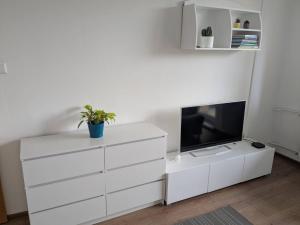 a living room with a white dresser and a tv at Summit Suite in Vysoké Tatry