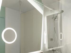 a bathroom with a shower with a glass door at ibis Longwy Mexy in Mexy +27 photos