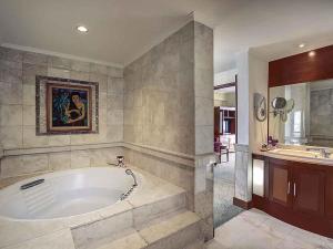 a large bathroom with a tub and a sink at Mercure Jakarta Kota in Jakarta