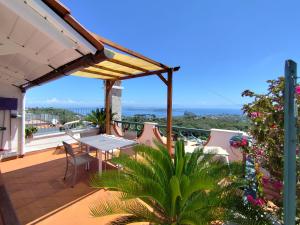a patio with a table and chairs on a balcony at Villa La Favola in Barano d'Ischia
