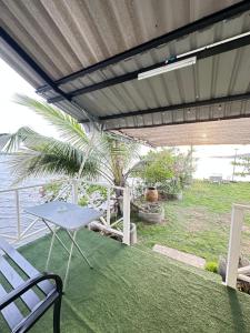 a patio with a table and a table and a bench at Summer Sunshine in Songkhla