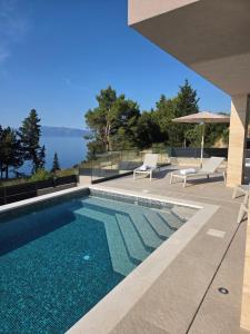 a swimming pool with a view of the water at Villa Tedi in Podaca
