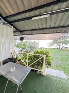 a patio with a table and a garden in the background at Summer Sunshine in Songkhla +5 photos