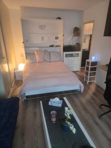 a bedroom with a bed and a table with flowers at Studio de vacances Stella Plage in Cucq