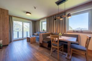 a living room with a table and chairs and a couch at Gasthof Bergblick in Berwang