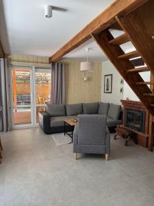 a living room with a couch and a fireplace at Chata przy lesie - sauna i balia in Łuka