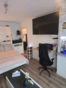 a bedroom with a bed and a desk and a chair at Studio de vacances Stella Plage in Cucq