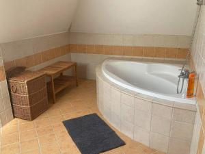 a bathroom with a tub and a table and a bench at La Perla Villa del Lago in Paloznak +15 photos