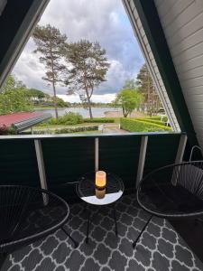 a balcony with two tables and a view of the water at Ferienhaus Conneforde in Wiefelstede