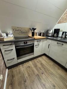 a kitchen with a stove and a counter top at Ferienhaus Conneforde in Wiefelstede
