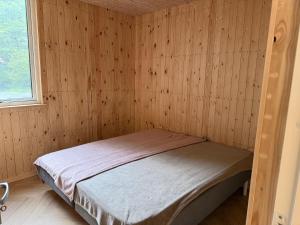 a bedroom with a bed in a wooden wall at Bornholm Eco Suites in Klemensker