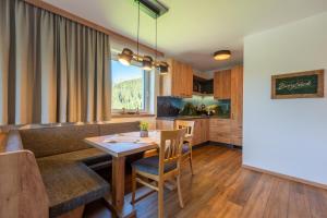 a kitchen and living room with a table and a couch at Gasthof Bergblick in Berwang