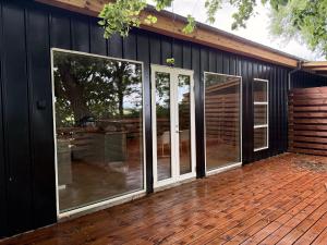 a screened in porch of a house with glass doors at Bornholm Eco Suites in Klemensker