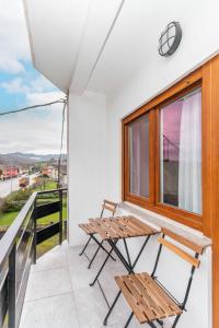 a balcony with two chairs and a window at Apartamento La Salamandra in Arriondas