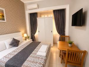 a bedroom with a bed and a table and a television at colombia inn cairo in Cairo +12 photos