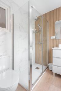 a white bathroom with a shower and a toilet at Apartamento La Salamandra in Arriondas