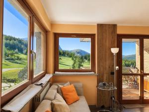 a living room with a couch and a large window at Hostdomus - Suite Les Etoiles in Sestriere