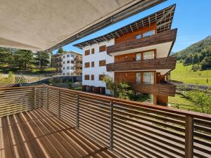 a balcony with a wooden fence and a building at Hostdomus - Suite Les Etoiles in Sestriere +28 photos