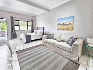 a living room with a couch and a bed at Manzini Chalet no20 in St Lucia +18 photos