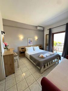 a hotel room with a bed and a balcony at Zefiros in Agios Ioannis Pelio