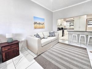 a living room with a white couch and a kitchen at Manzini Chalet no20 in St Lucia