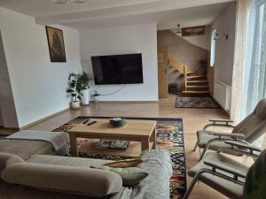 a living room with a couch and a table and a tv at Dom nad jeziorem in Rokity