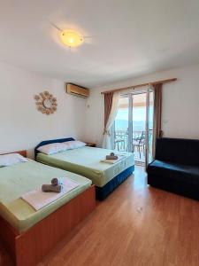 a room with two beds and a couch and a balcony at Apartment & Rooms Tempera in Neum