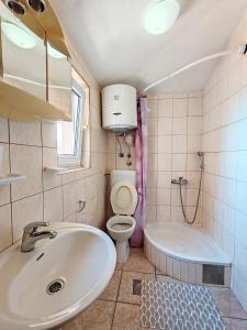a bathroom with a sink and a toilet and a tub at Apartment & Rooms Tempera in Neum +31 photos