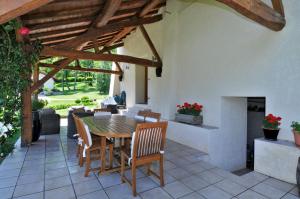 a patio with a table and chairs and a fireplace at La Grange de mon Père in Traize