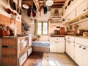 a kitchen with white cabinets and a window at Chichotavá breza in Liptovská Anna