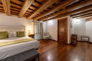 a bedroom with a large bed and wooden floors at Hotel Villa Retiro in Xerta