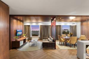 a living room with a table and a dining room at Southern Sun Rosebank, Johannesburg in Johannesburg