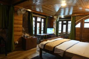 a bedroom with a bed and a desk with a television at Quinton Enclave in Shillong +4 photos