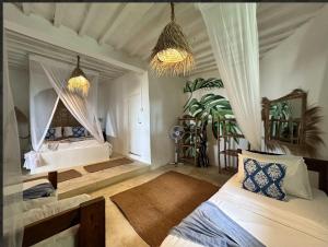 a bedroom with two beds and a chandelier at Garden Beach Bungalows Jambiani in Jambiani