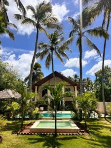 a resort with a swimming pool and palm trees at Ocean Divine Villa in Kalametiya