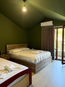 two beds in a room with green walls at Artist House in Pogradec +25 photos