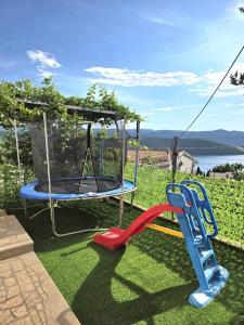 a playground with a swing and a slide at Apartment & Rooms Tempera in Neum