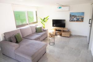 a living room with a couch and a flat screen tv at Row 7 Holiday Homes in Kyrenia