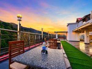 a bottle of water sitting on a table on a balcony at Hotel Woods inn Dalhousie #MBS Travels # Rooftop # Restaurant # Top Rated Property in Dalhousie +11 photos