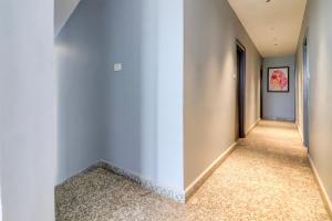 a hallway with white walls and carpeted floors at Super Hotel O Gold Inn in Rohtak