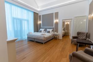 a bedroom with a bed and a couch and a chair at Crama Venetic in Prundeni