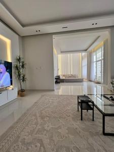 a living room with a glass table and a couch at فيلا صلاله بالم salalah palm villa in Salalah
