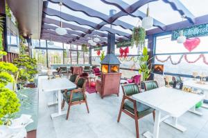 a restaurant with tables and chairs and a fireplace at Poison Garden Suite & SPA in Gözalan