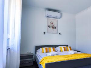 a bedroom with a bed with a yellow blanket at Banova Vendégház in Császártöltés