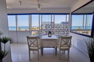 a dining room with a table and chairs and the ocean at Beachfront Apartment with Sea Views & Pool - El Puig in El Puig